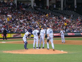 Pitcher, catcher, manager and first baseman meeting on mound