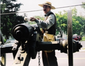 Man showing how to load a cannon in period dress